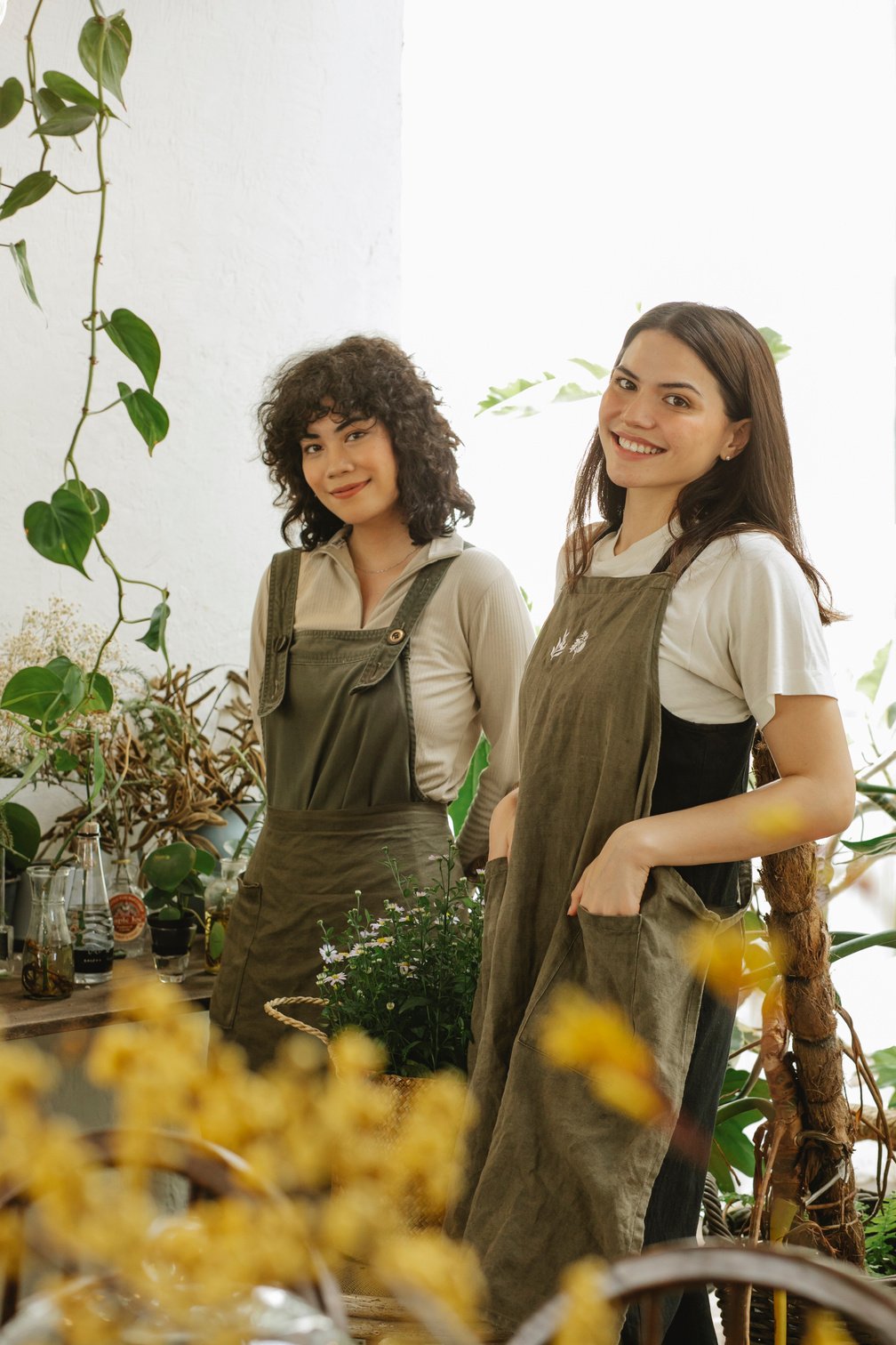 Positive florists in aprons looking at camera